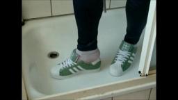 Jana tramples on bed with her shiny green Adidas Superstars and messes up both and then washes them