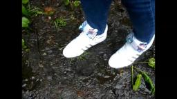 Jana walks with her Adidas Top Ten white patent with loop through the mud yt trailer